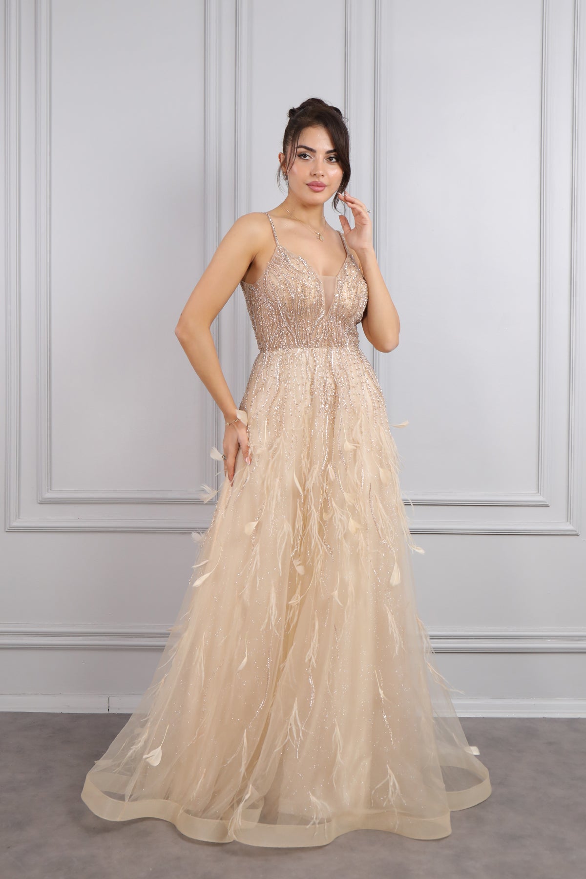 فستان سهرة بحمالات رفيعة وفتحة كبيرة في الصدر مع تفاصيل ريش من "المجموعة الخاصة" -ذهبي