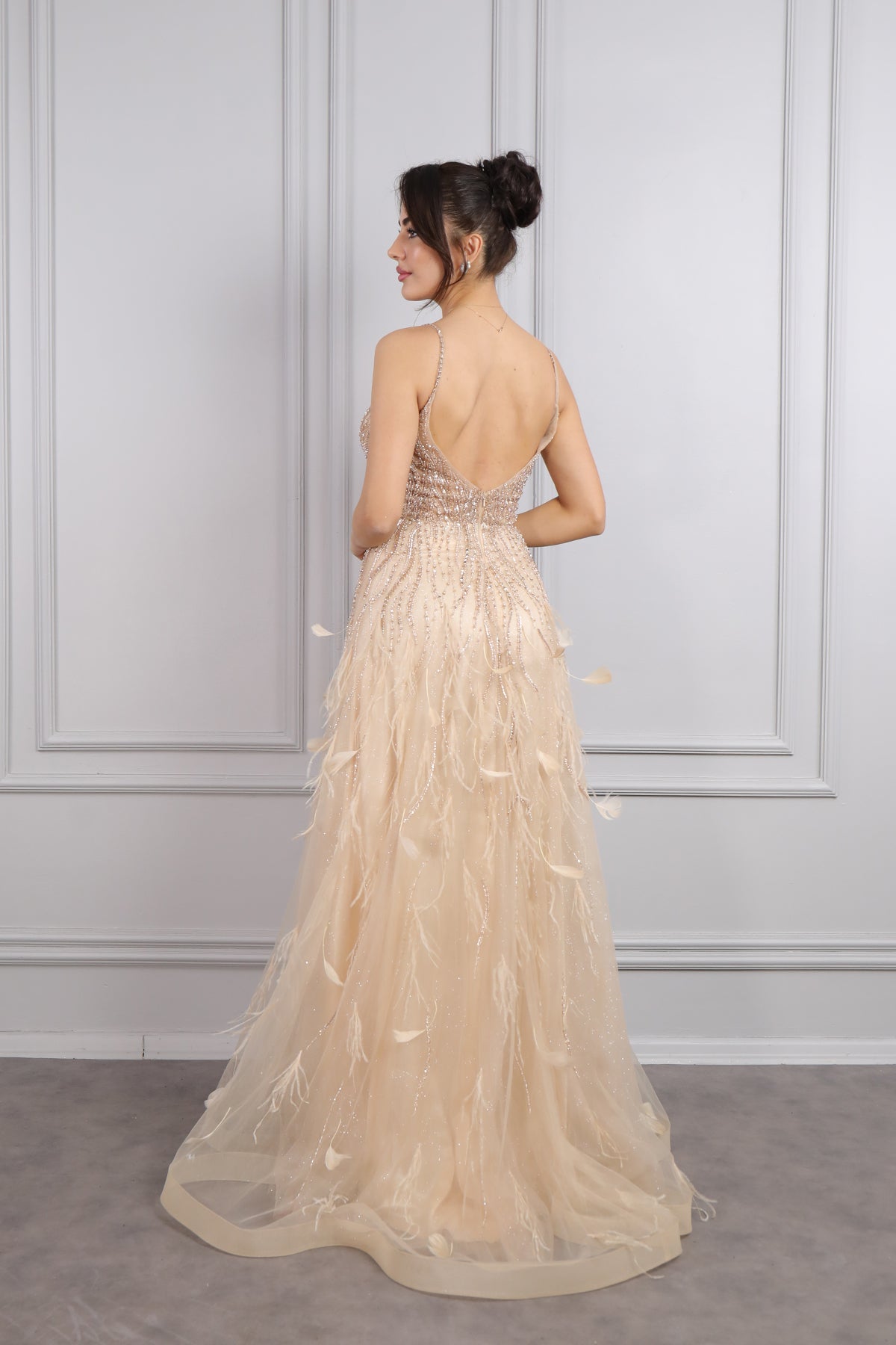 فستان سهرة بحمالات رفيعة وفتحة كبيرة في الصدر مع تفاصيل ريش من "المجموعة الخاصة" -ذهبي