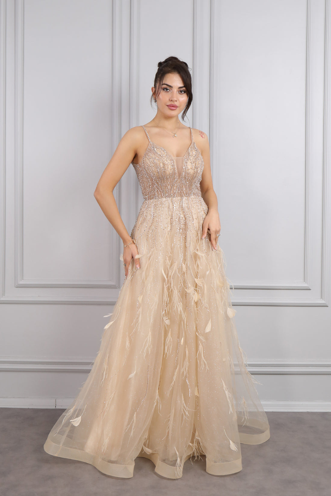 فستان سهرة بحمالات رفيعة وفتحة كبيرة في الصدر مع تفاصيل ريش من "المجموعة الخاصة" -ذهبي