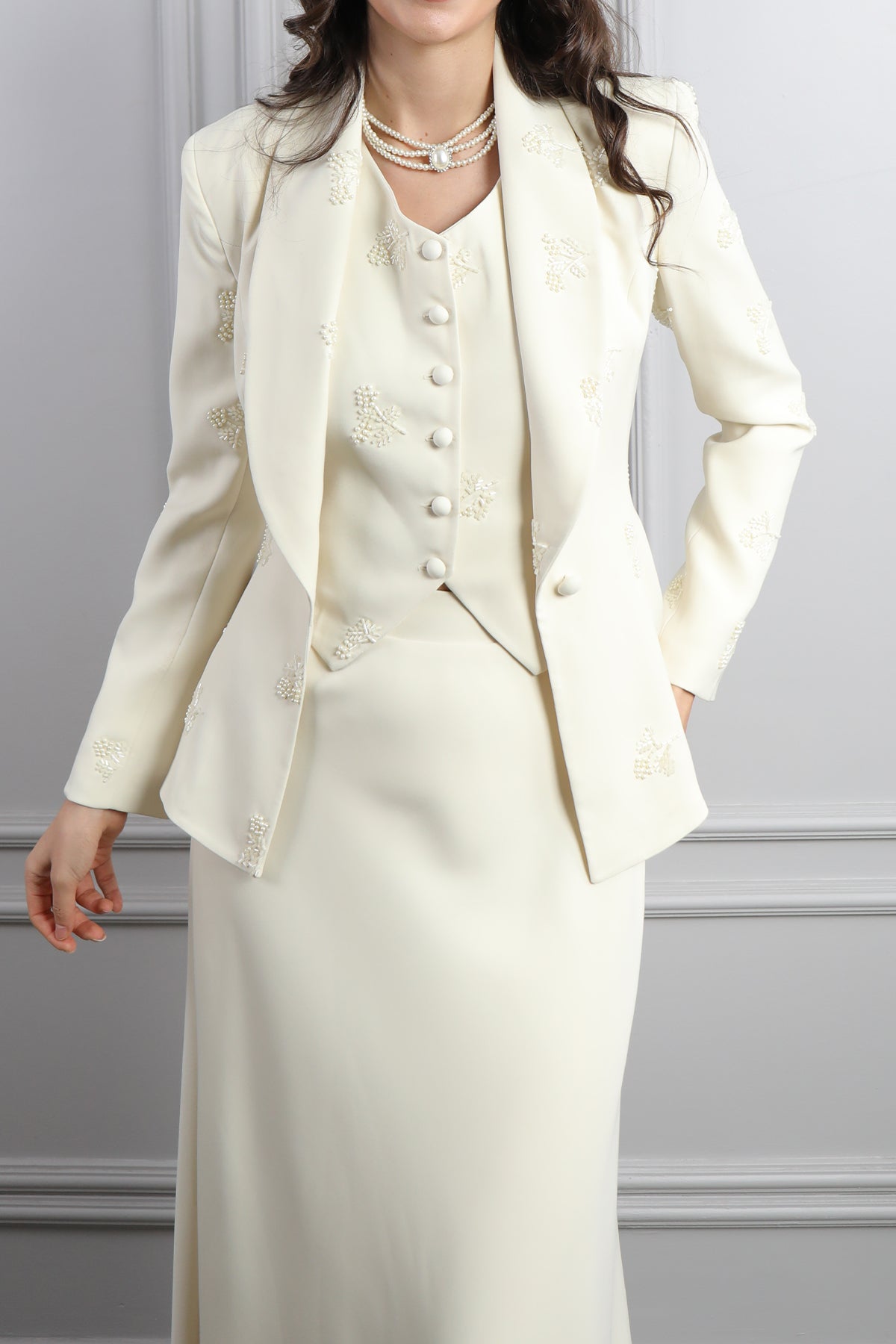 طقم ثلاثي بتنورة وجاكيت بتطريزات خرزية وتفاصيل ربط في الخلف -بيج