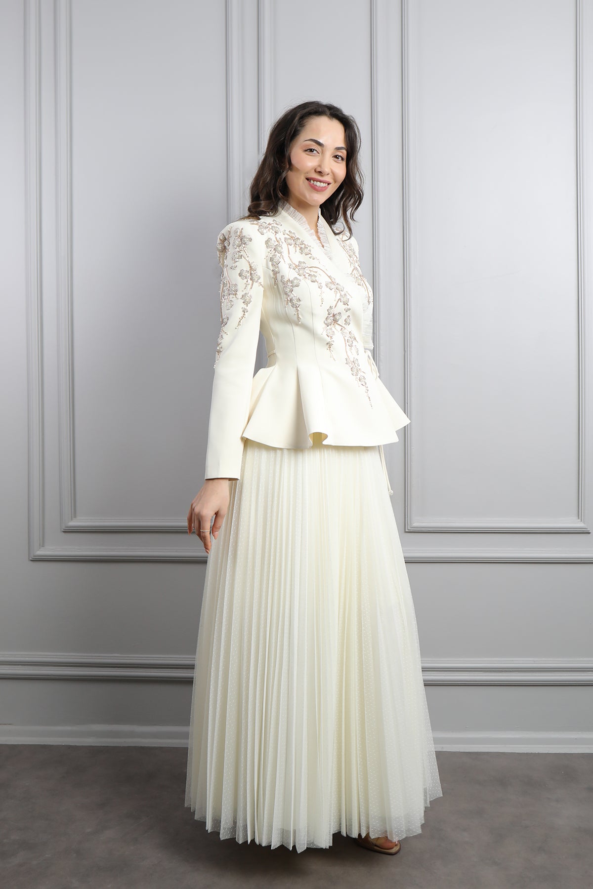 طقم تنورة بتكسيرات وجاكيت مزين بتطريزات خرزية وكشكشة -سكري